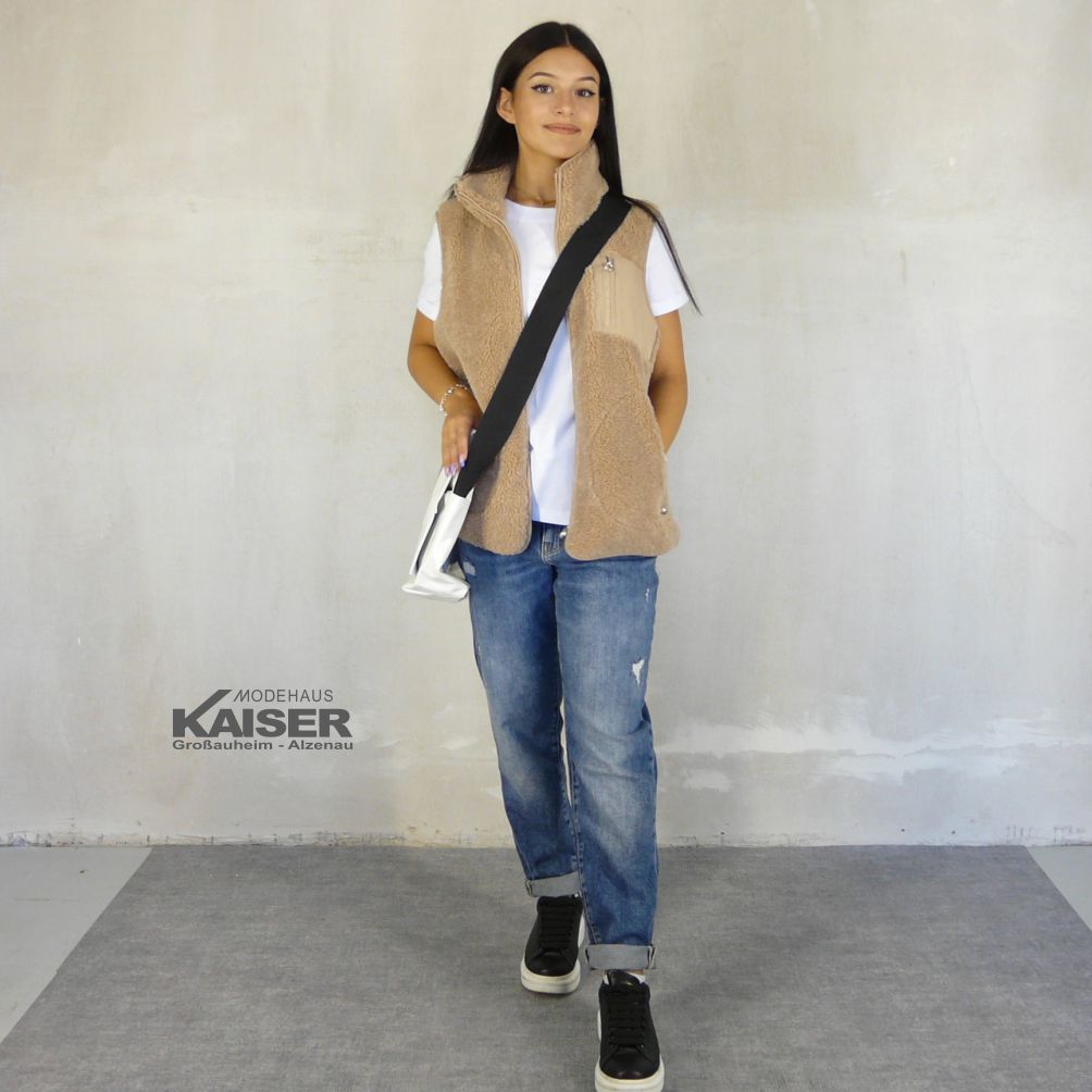 Damenlook mit beiger Teddyweste, weißem Shirt, Jeans und Umhängetasche